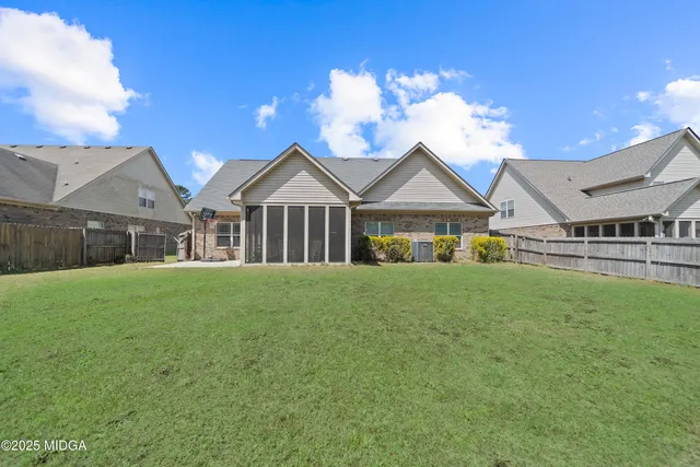 a view of a house with a big yard potted plants and large tree
