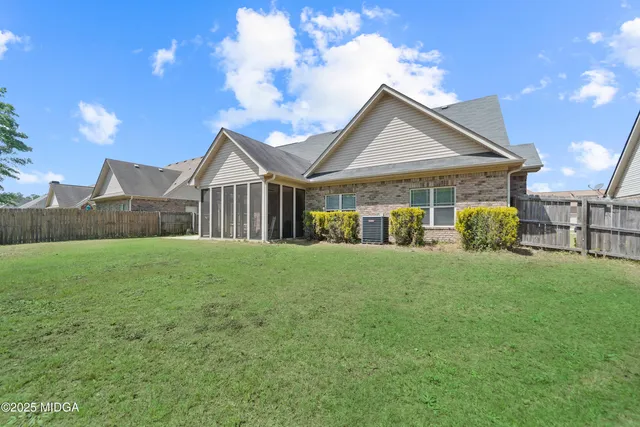 a view of a house next to a yard with big trees