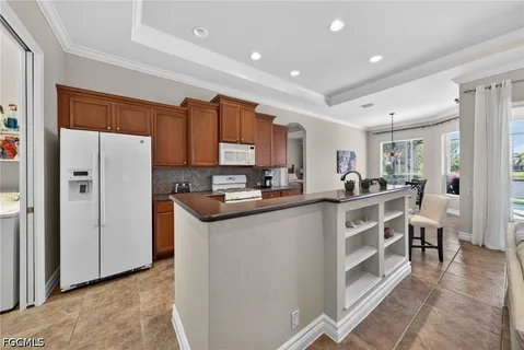 a kitchen with stainless steel appliances granite countertop a stove top oven a sink dishwasher a dining table and chairs with wooden floor