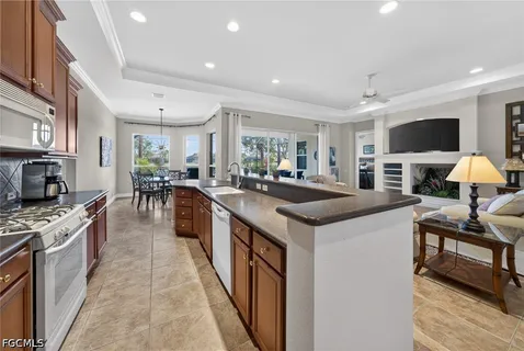 a large kitchen with kitchen island a counter top space a sink stainless steel appliances and cabinets