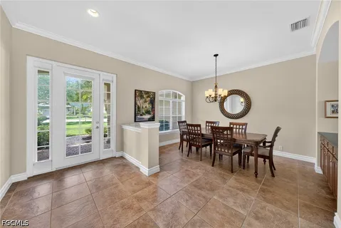 a view of a dining room and livingroom with furniture wooden floor a chandelier