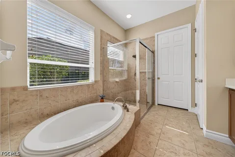 a bedroom with a bed flat screen tv and a large window