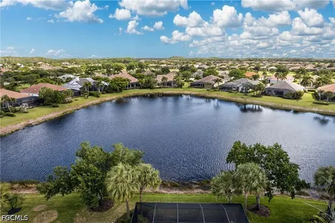 a front view of a house with a yard and palm trees