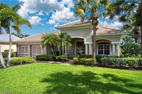 a view of a white house with a yard and potted plants