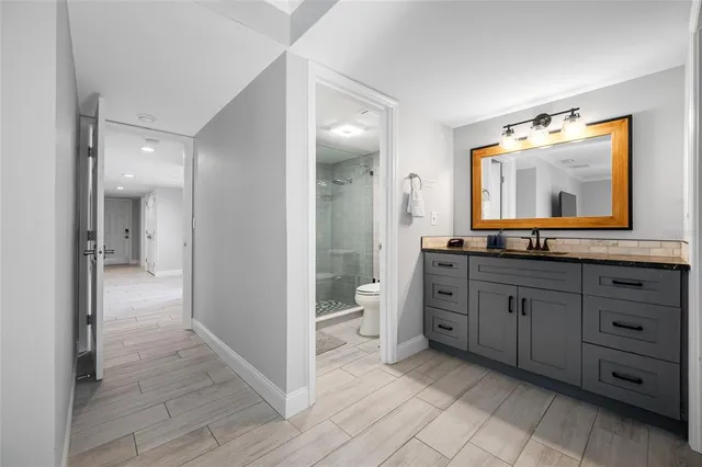 a bathroom with a granite countertop sink toilet and a mirror