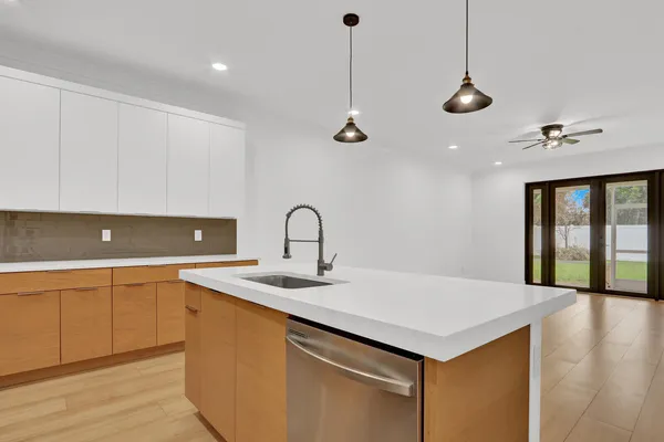 a kitchen with a sink a counter space appliances and cabinets