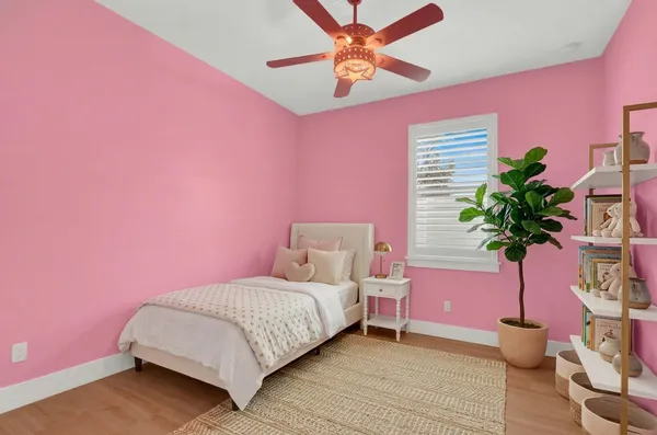 a bedroom with a bed potted plant and a dresser