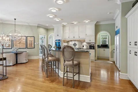 a view of a dining room kitchen counter top space a stove and wooden floor
