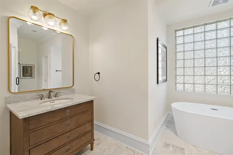 a bathroom with a tub sink and mirror