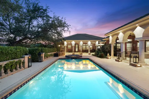 a view of a house with swimming pool and sitting area