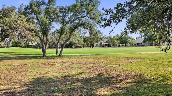 a view of a field with trees in the background