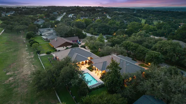 an aerial view of residential house with outdoor space and trees all around