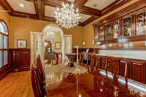 a view of a dining room with furniture a chandelier and wooden floor