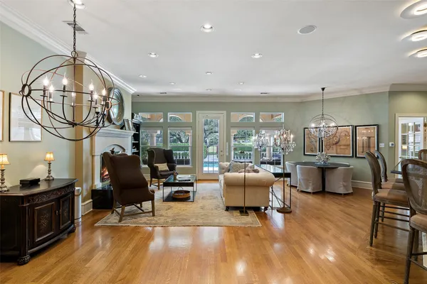 a living room with furniture a rug kitchen view and large windows
