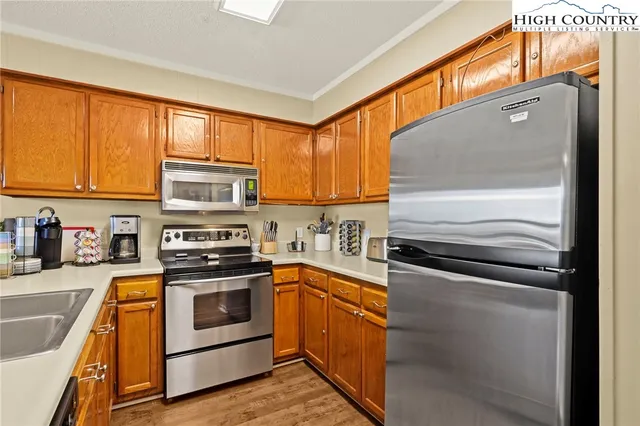 a kitchen with stainless steel appliances a stove a sink and a microwave