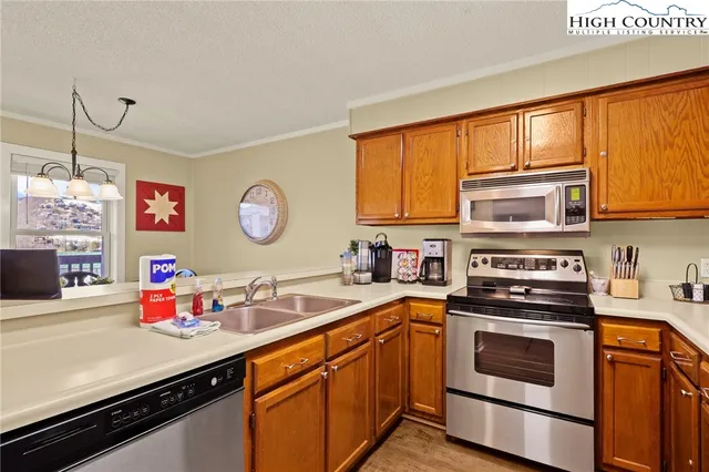 a view of a dining room with furniture a chandelier and wooden floor