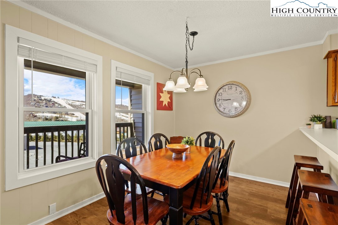 301 Pinnacle Inn Road, Unit 3305 Beech Mountain, NC 28604 - Photo 14 of 29 a view of a dining room with furniture a chandelier and wooden floor