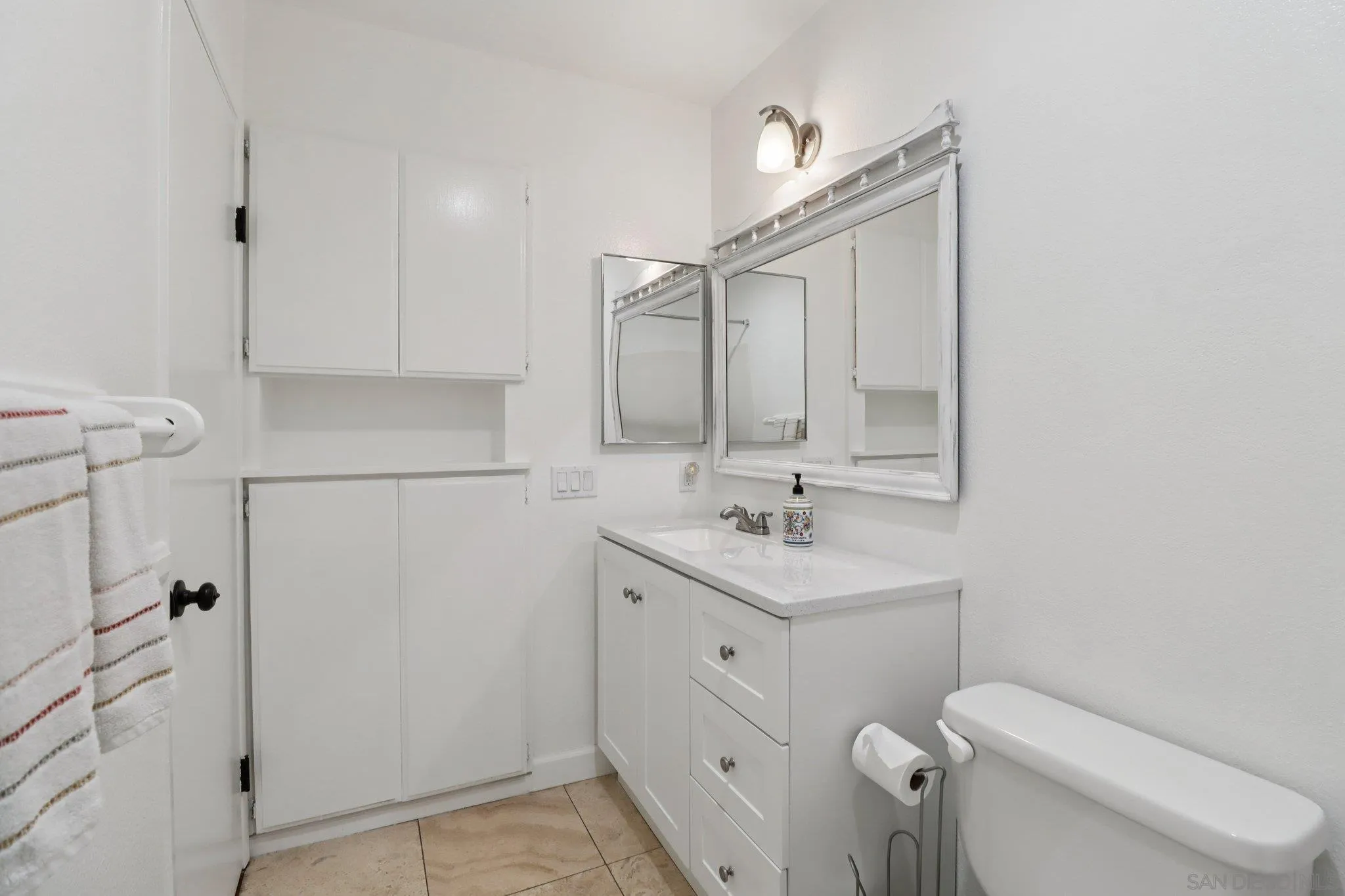 816 Caminito Azul Carlsbad, CA 92011 - Photo 22 of 41 a bathroom with a toilet a sink a mirror and vanity