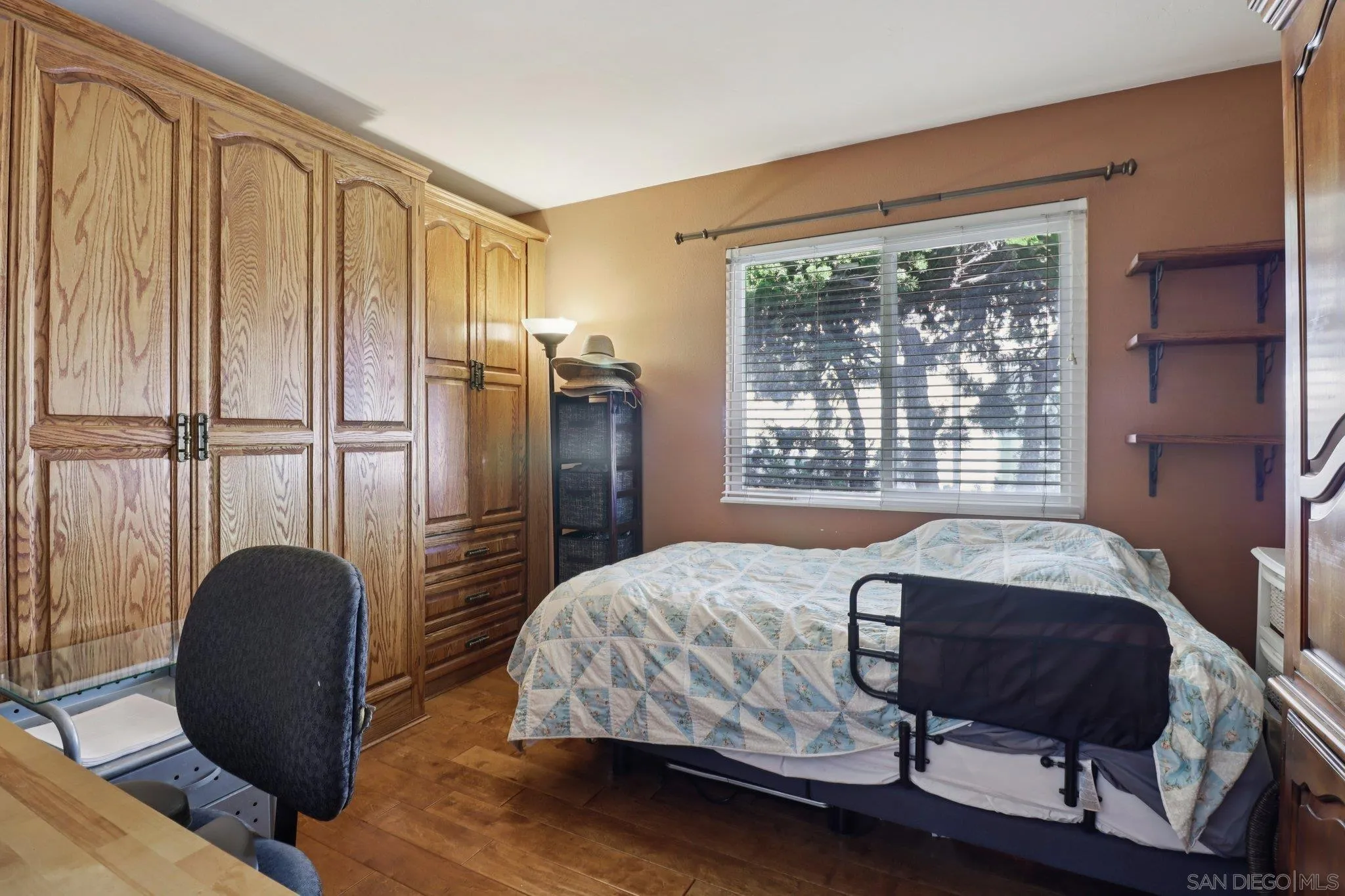 816 Caminito Azul Carlsbad, CA 92011 - Photo 23 of 41 a bedroom with a bed and wooden floor