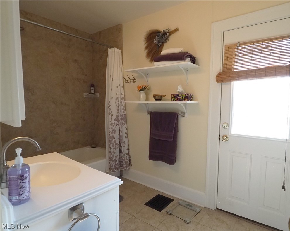 3060 Yorkshire Road Cleveland, OH 44118 - Photo 25 of 35 Bathroom with vanity, tile floors, a healthy amount of sunlight, and shower / tub combo