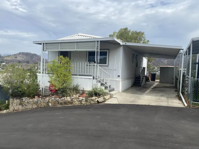 a front view of a house with a yard outdoor seating and mountain view