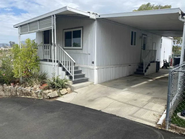 a view of a house with a yard and potted plants