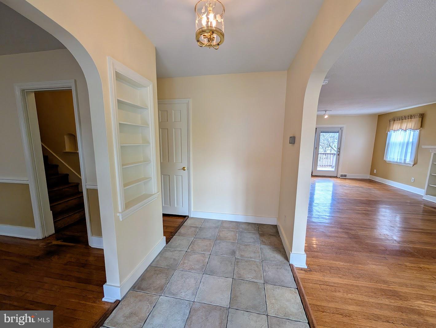 411 Devon Road Camp Hill, PA 17011 - Photo 13 of 33 a view of a hallway to an empty room with wooden floor and a chandelier