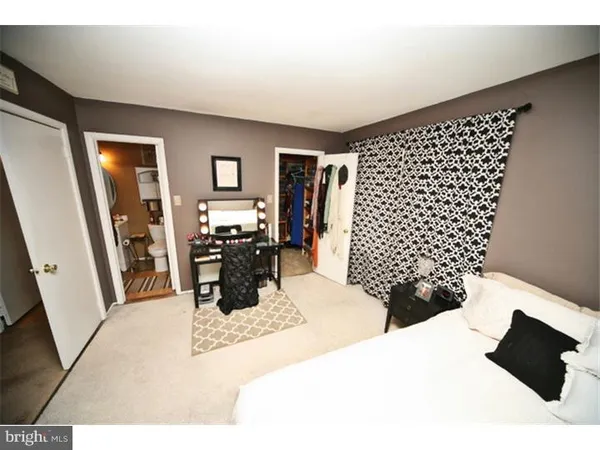 a bedroom with bed and a mirror