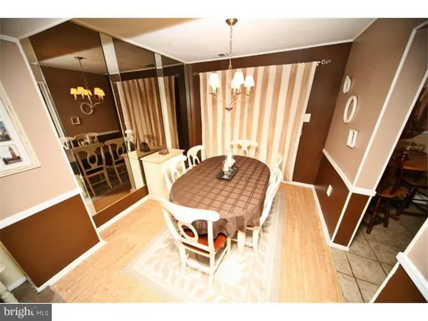 a living room with chairs a dining table and a wooden floor