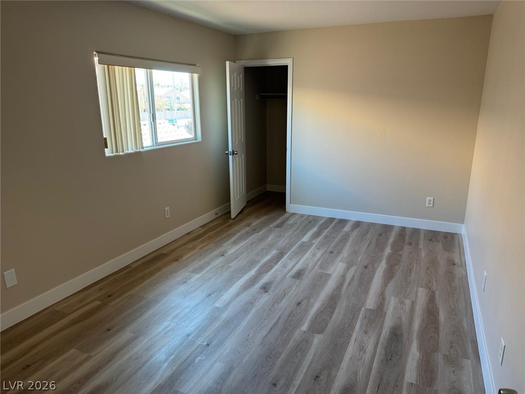 3962 Coyote Ridge Court Las Vegas, NV 89129 - Photo 31 of 35 A well-lit bedroom features durable laminate flooring and a spacious closet.
