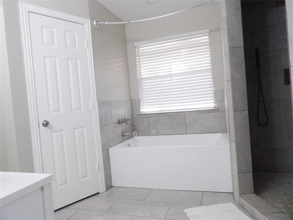 223 Juniper Ridge Court DeSoto, TX 75115 - Photo 18 of 33 Bathroom featuring a tiled shower, separate bath, and light tile patterned flooring