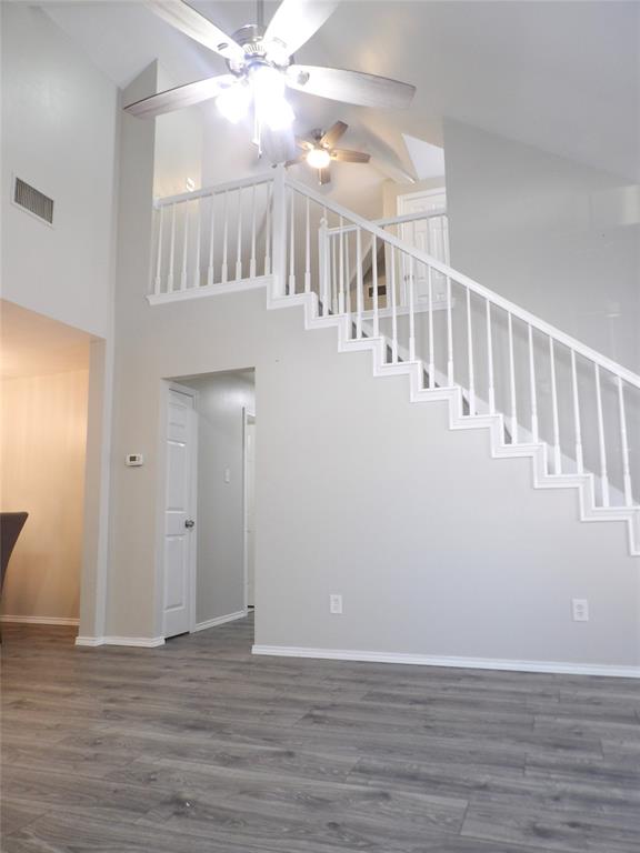 223 Juniper Ridge Court DeSoto, TX 75115 - Photo 31 of 33 Unfurnished living room with a ceiling fan, dark wood finished floors, and a high ceiling