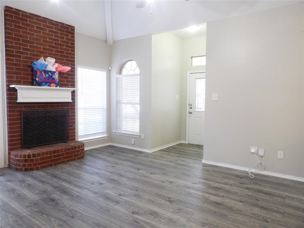223 Juniper Ridge Court DeSoto, TX 75115 - Photo 5 of 33 Unfurnished living room with beam ceiling, a fireplace, dark wood-style floors, and ceiling fan