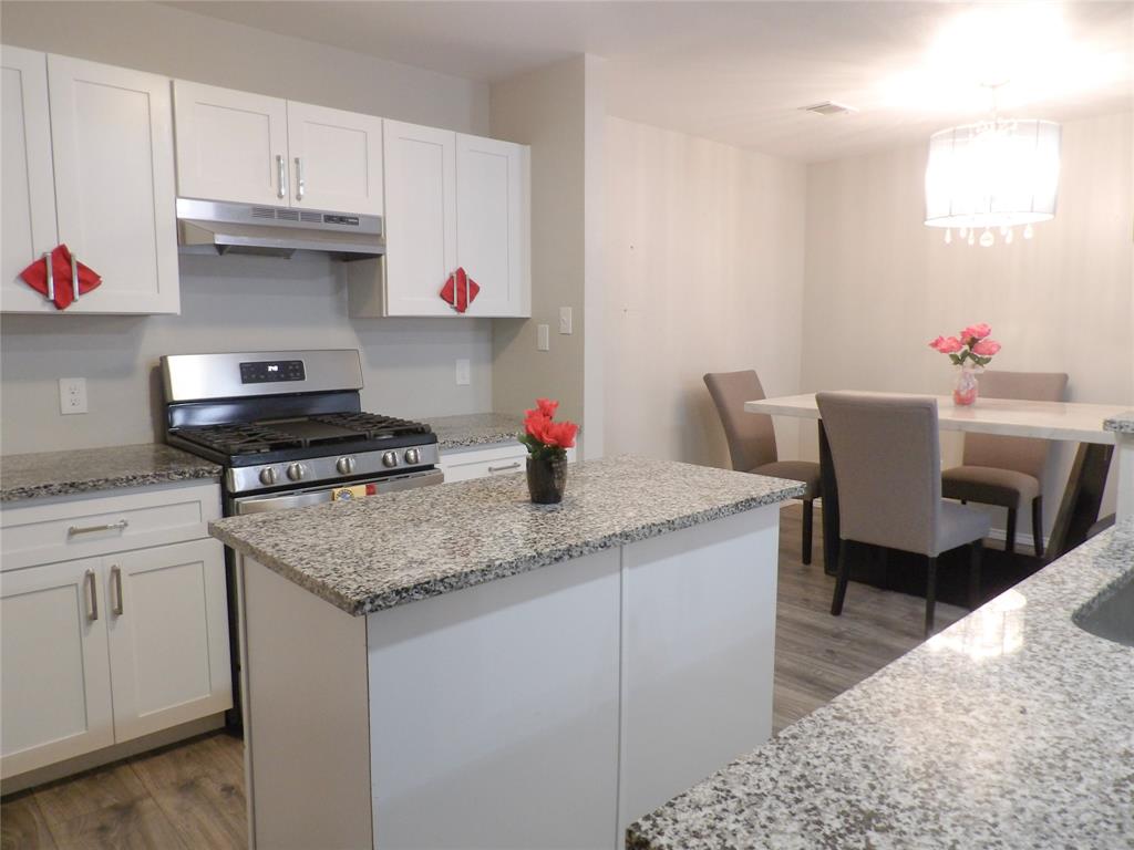 223 Juniper Ridge Court DeSoto, TX 75115 - Photo 9 of 33 Kitchen with stainless steel range with gas stovetop, dark wood finished floors, white cabinets, and light stone counters