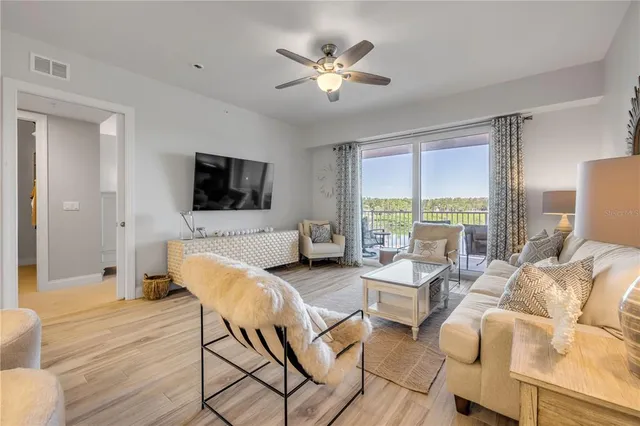 a living room with furniture a window and wooden floor