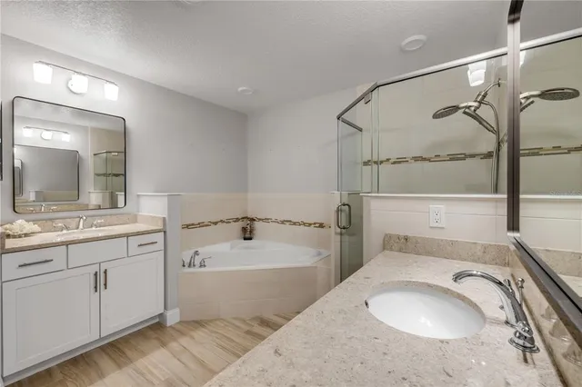 a bathroom with a granite countertop shower sink vanity and mirror
