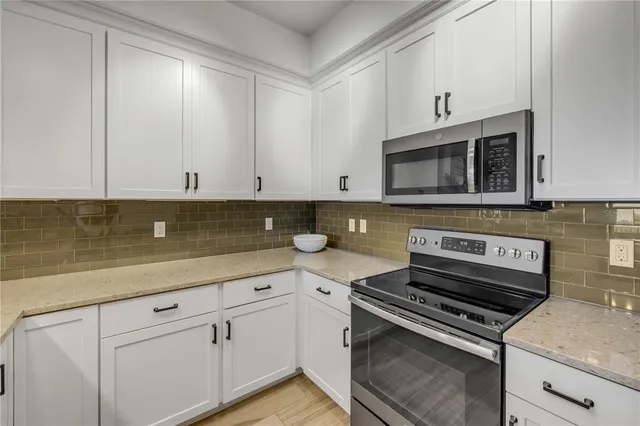 a kitchen with appliances a sink and cabinets