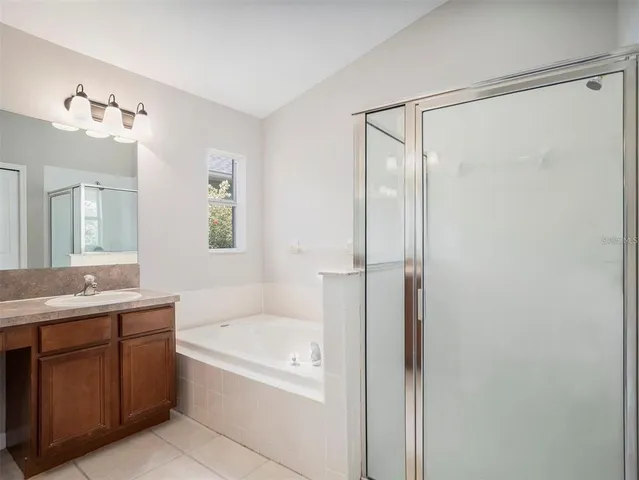 a bathroom with a tub shower vanity and a sink