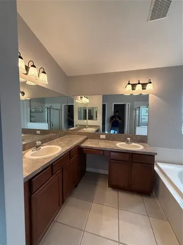an empty room with wooden floor and windows with curtains