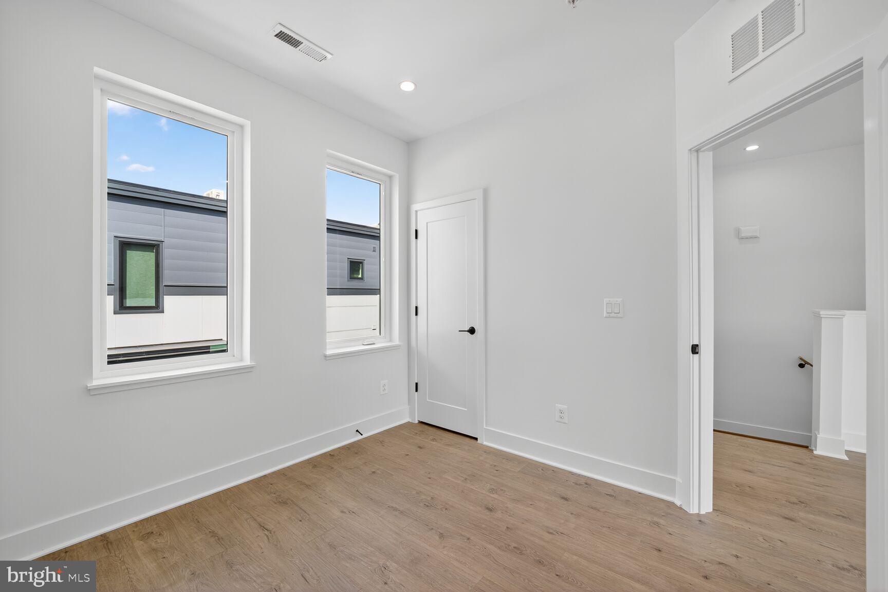 61 Lower Service Road Northwest, Unit HOMESITE 940 Washington, DC 20422 - Photo 23 of 26 an empty room with wooden floor and windows