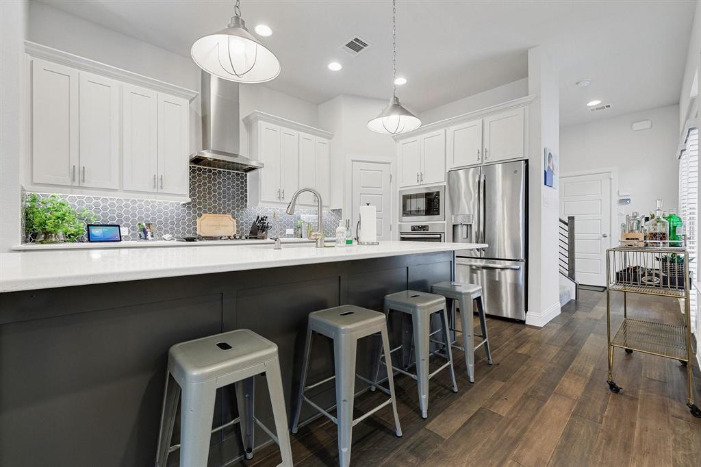 648 Aspen Valley Lane Dallas, TX 75208 - Photo 11 of 38 a kitchen with stainless steel appliances a dining table chairs sink and cabinets