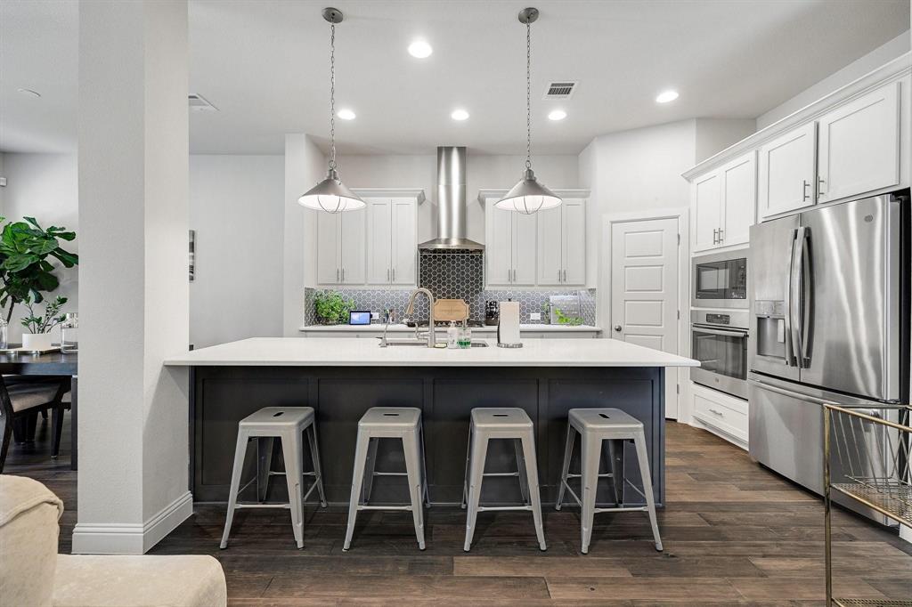648 Aspen Valley Lane Dallas, TX 75208 - Photo 10 of 38 a kitchen with granite countertop a table chairs stainless steel appliances and wooden floor
