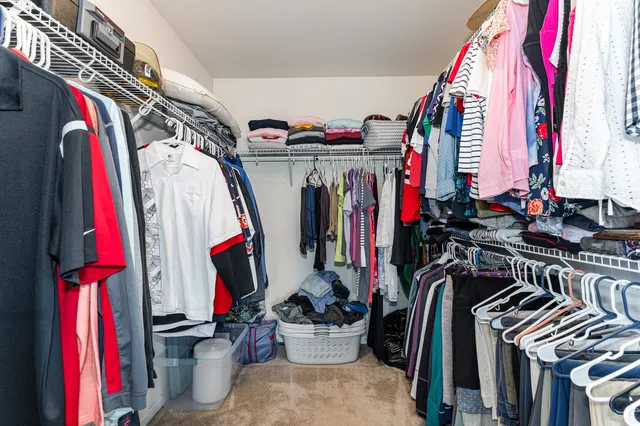 a view of walk in closet with clothes