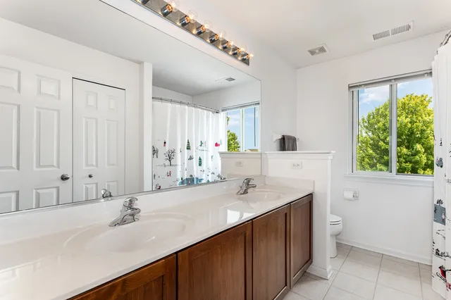 a bathroom with a double vanity sink a mirror and a bathtub