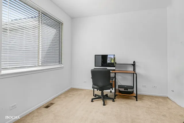 a view of a workspace with furniture and a window