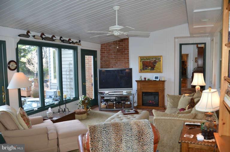 7891 Fuller Road St. Michaels, MD 21663 - Photo 11 of 23 a living room with furniture a fireplace and a flat screen tv