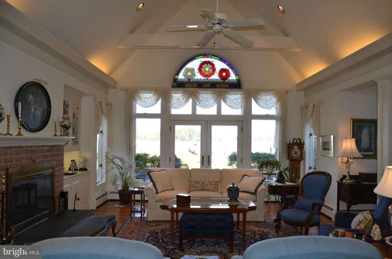 7891 Fuller Road St. Michaels, MD 21663 - Photo 15 of 23 a living room with furniture a fireplace and a floor to ceiling window