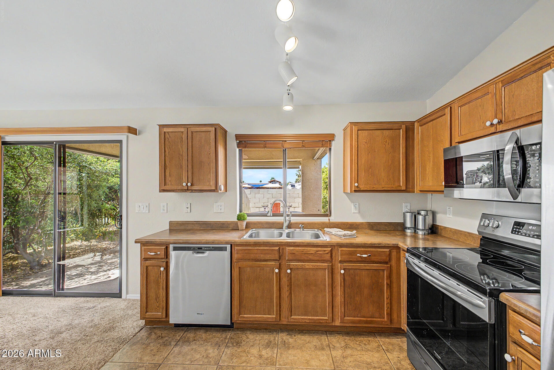 2101 South Meridian Road, Unit 133 Apache Junction, AZ 85120 - Photo 16 of 51 a kitchen with stainless steel appliances granite countertop a stove top oven a sink dishwasher a dining table and chairs with wooden floor