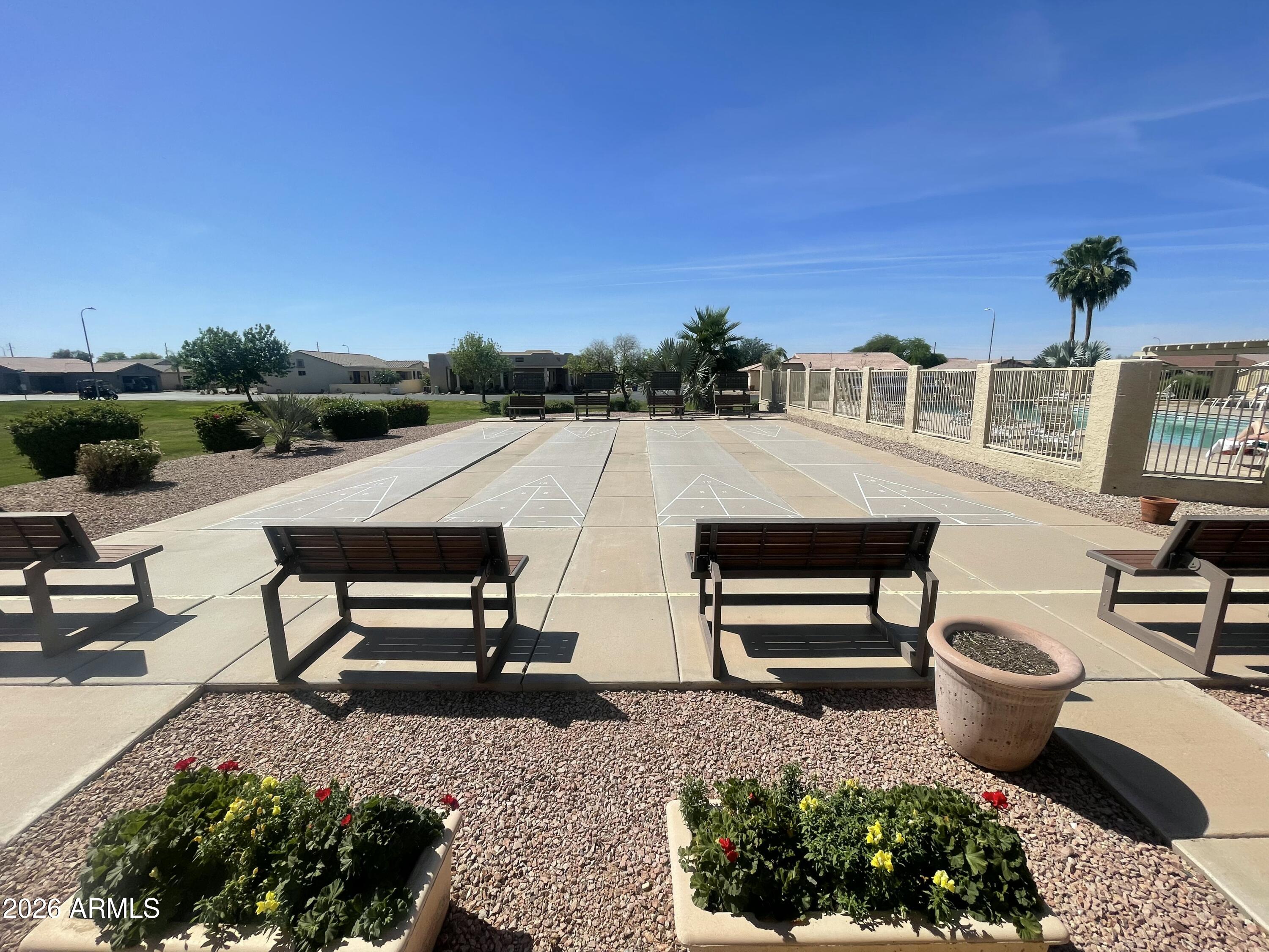 2101 South Meridian Road, Unit 133 Apache Junction, AZ 85120 - Photo 46 of 51 a view of a patio with table and chairs potted plants with wooden fence