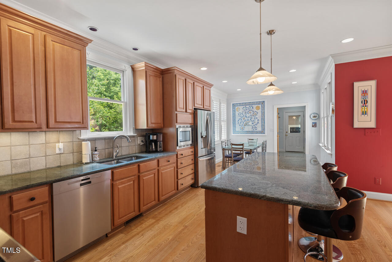 30119 Settle Chapel Hill, NC 27517 - Photo 18 of 49 a kitchen with stainless steel appliances granite countertop counter space a sink cabinets and wooden floor